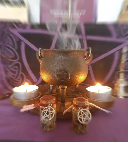Cauldron with burning sage smoke and lit candles creating sacred space for home cleansing ritual - traditional smudging setup with pentagram charms for spiritual protection